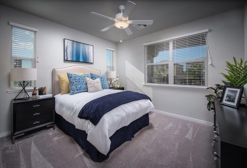 1 BR Apartments in Roseville CA - Harvest at Fiddyment Ranch - Bedroom with Plush Carpeting, Multiple Windows, and a Ceiling Fan