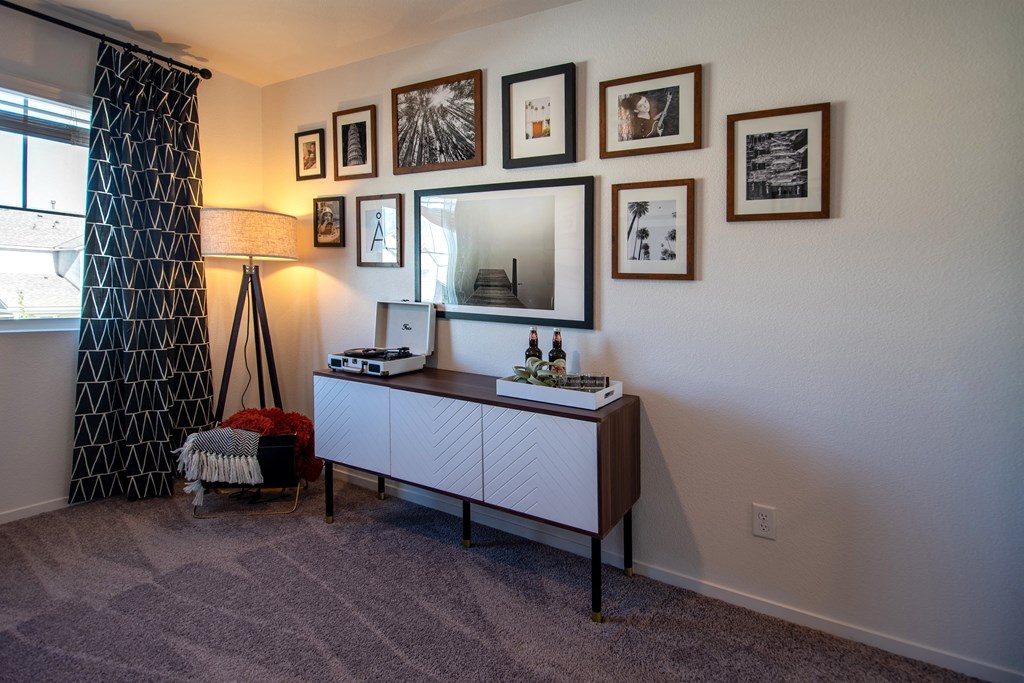 living room with pictures on the wall and a dresser