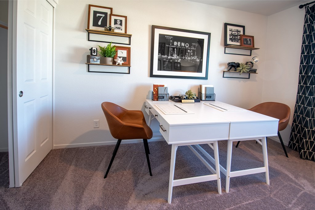 a home office with a white desk and two chairs