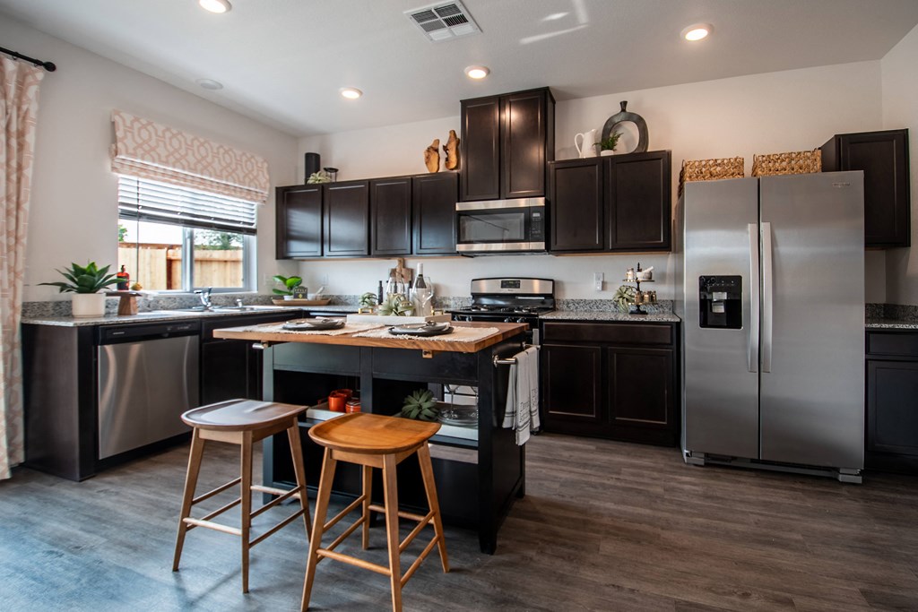 a kitchen with stainless steel appliances and a island with two stools