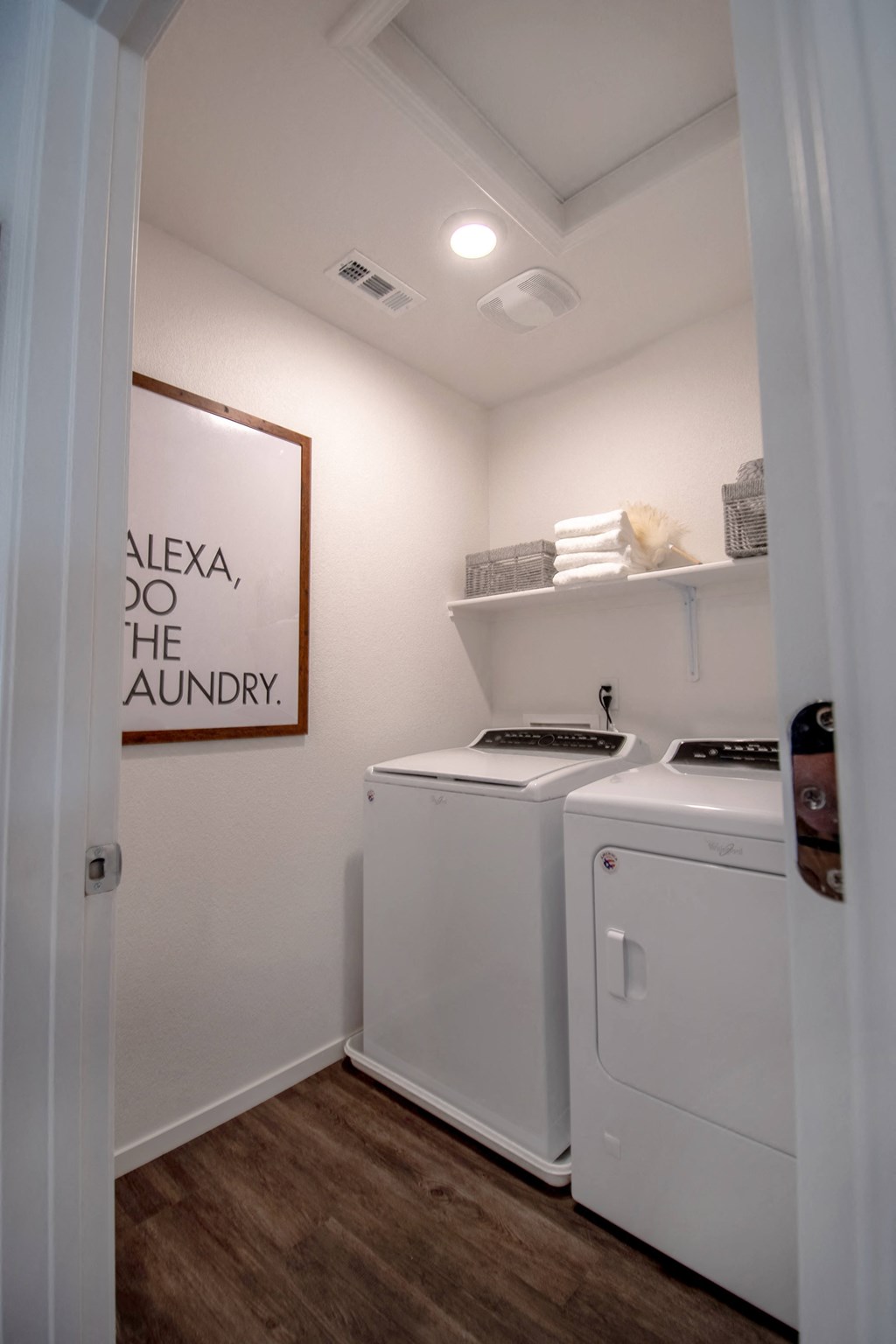 a laundry room with a washer and dryer and a sign on the wall