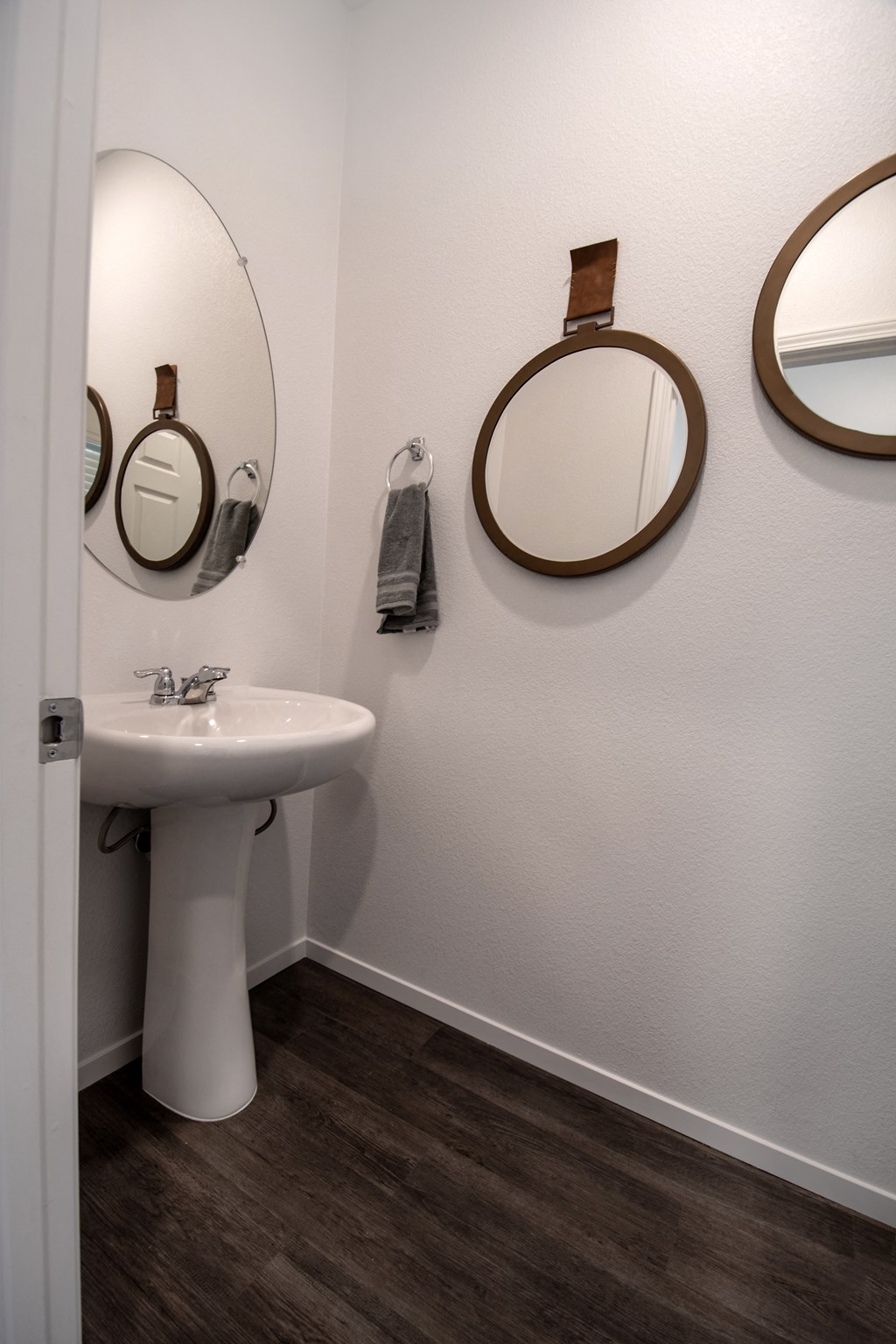 a bathroom with a sink and three mirrors on the wall