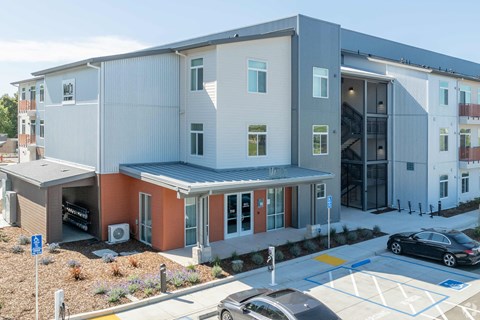 a new apartment building with cars parked in front of it