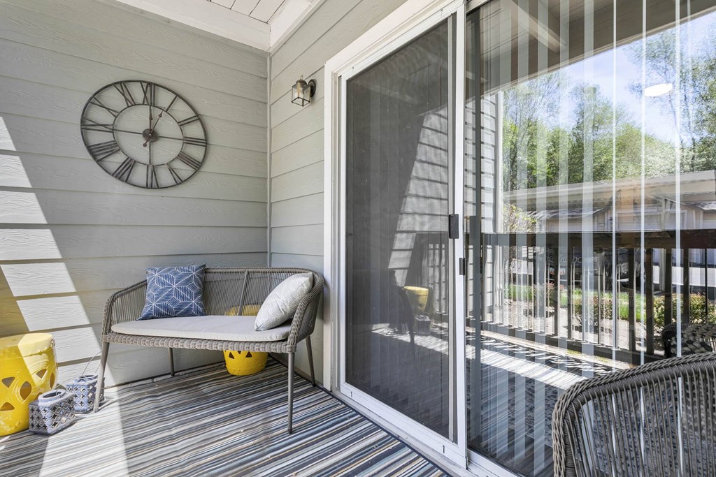 a patio with a chair and a clock on the wall at Ascent Apartments, Cottonwood Heights, UT