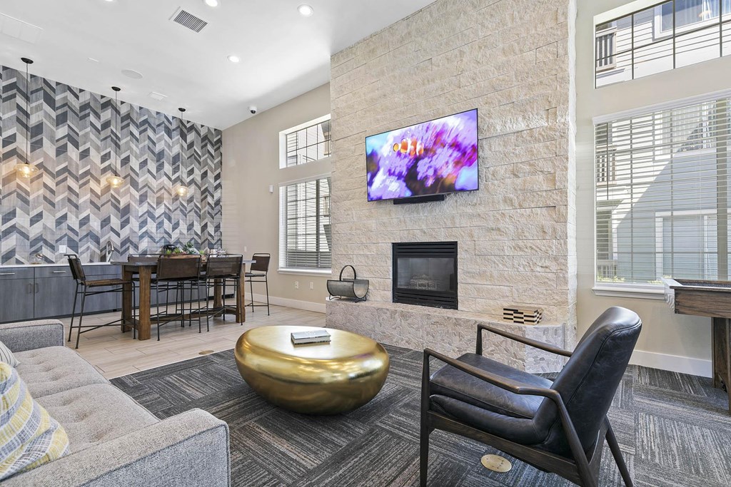 a living room with a fireplace and a table with chairs at Ascent Apartments, Cottonwood Heights, UT