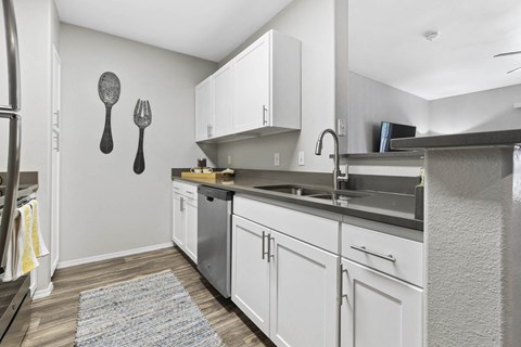 a kitchen with white cabinets and a sink