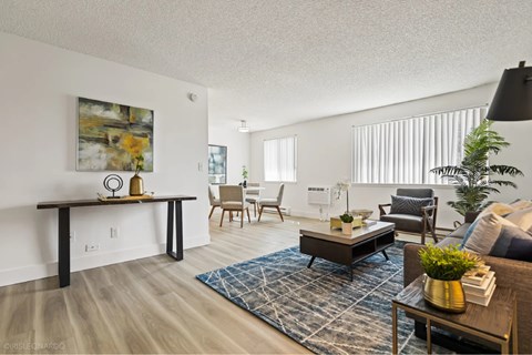 A living room with a large painting on the wall and a wooden coffee table in the center.