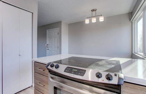 A modern kitchen with a stainless steel oven and a white cabinet.