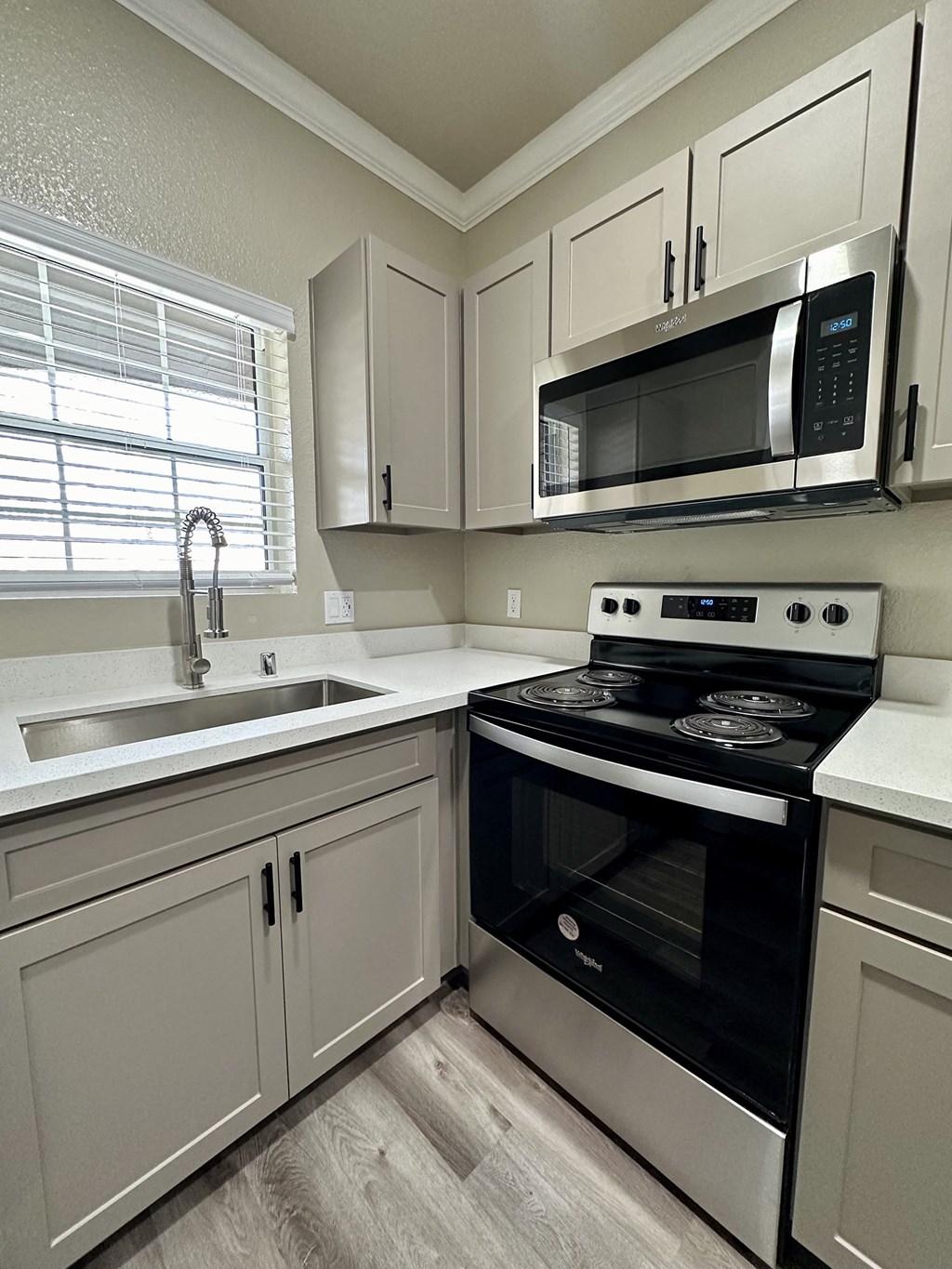 a kitchen with white cabinets and a black stove and microwave