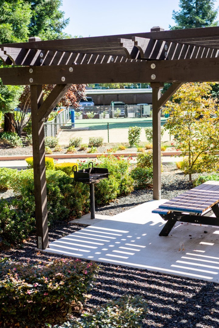 a picnic table under a wooden pergola