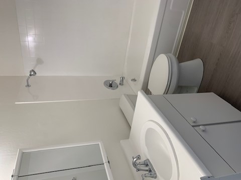 A white toilet with a white sink and a white bathtub with a glass door.at OTAVON APARTMENTS, Novato
