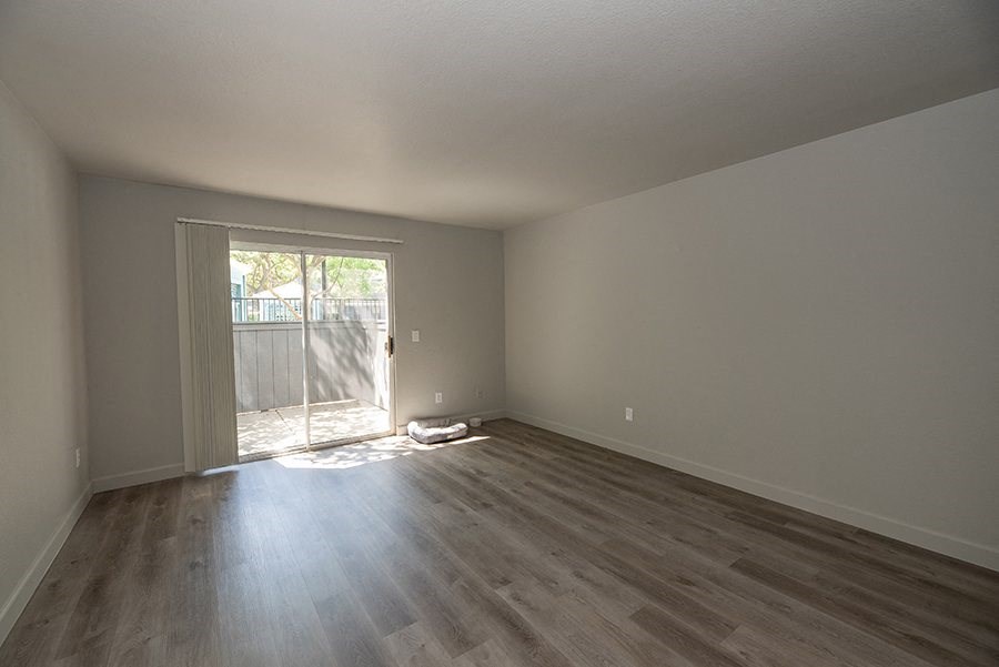 a bedroom with hardwood floors and a sliding glass door to the backyard