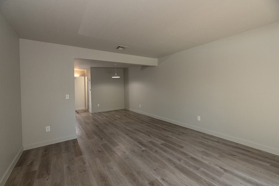 an empty living room with a hardwood floor