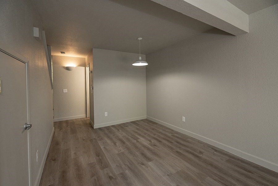 a bedroom with hardwood floors and grey walls