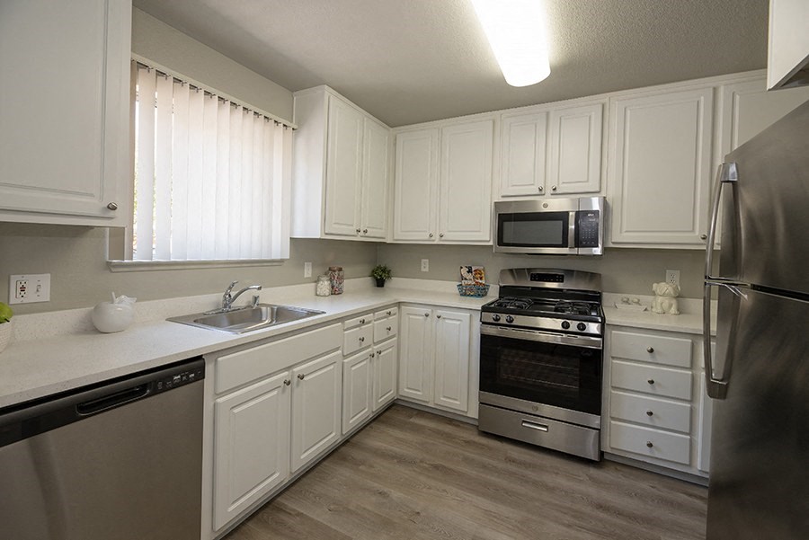a kitchen with white cabinets and stainless steel appliances