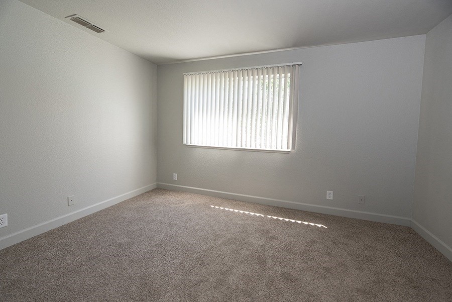 a bedroom with gray walls and a window