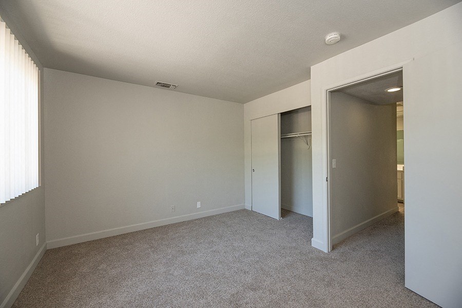 a bedroom with a closet and a window