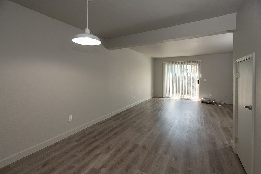 a bedroom with hardwood floors and a sliding glass door
