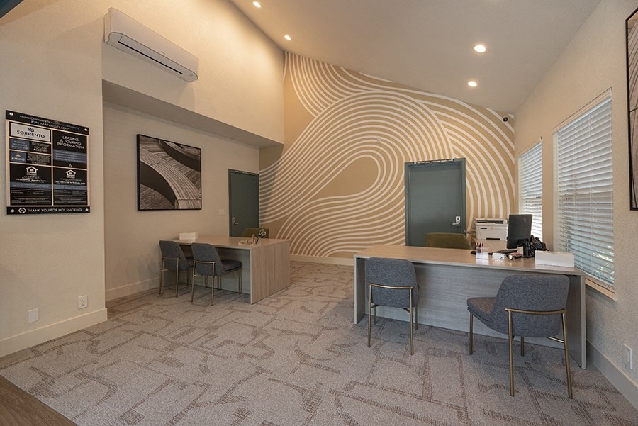 a room with a desk and chairs