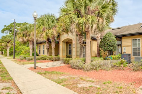 A row of houses with a sidewalk in front.