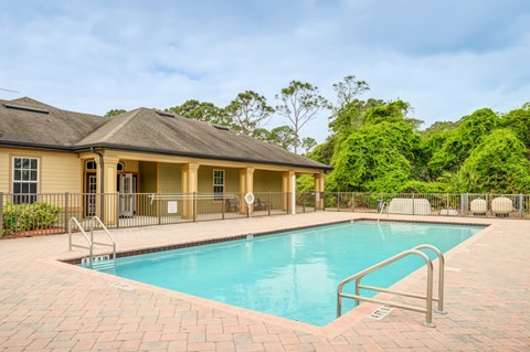 A pool in a house surrounded by trees.
