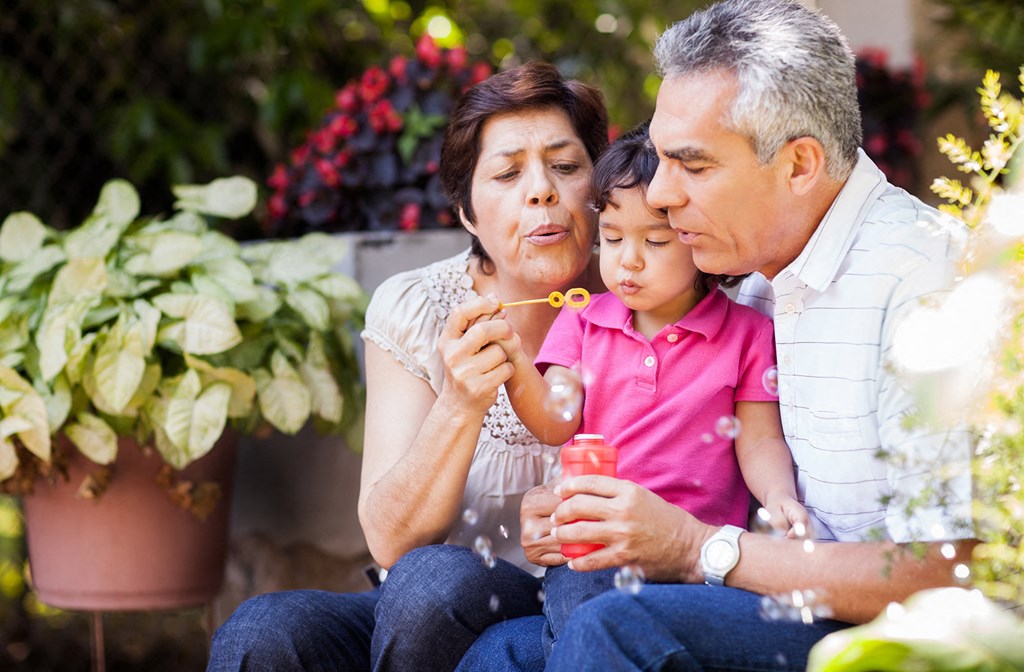 Lifestyle photo of grandparents blowing bubbles with grandchild at Oaks at Pompano, Pompano Beach, FL