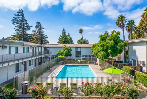 a resort style pool is surrounded by buildings and trees