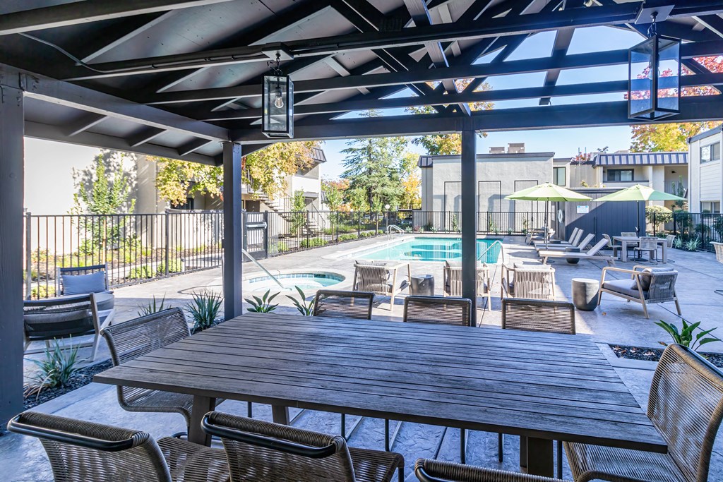 a patio with a table and chairs and a swimming pool