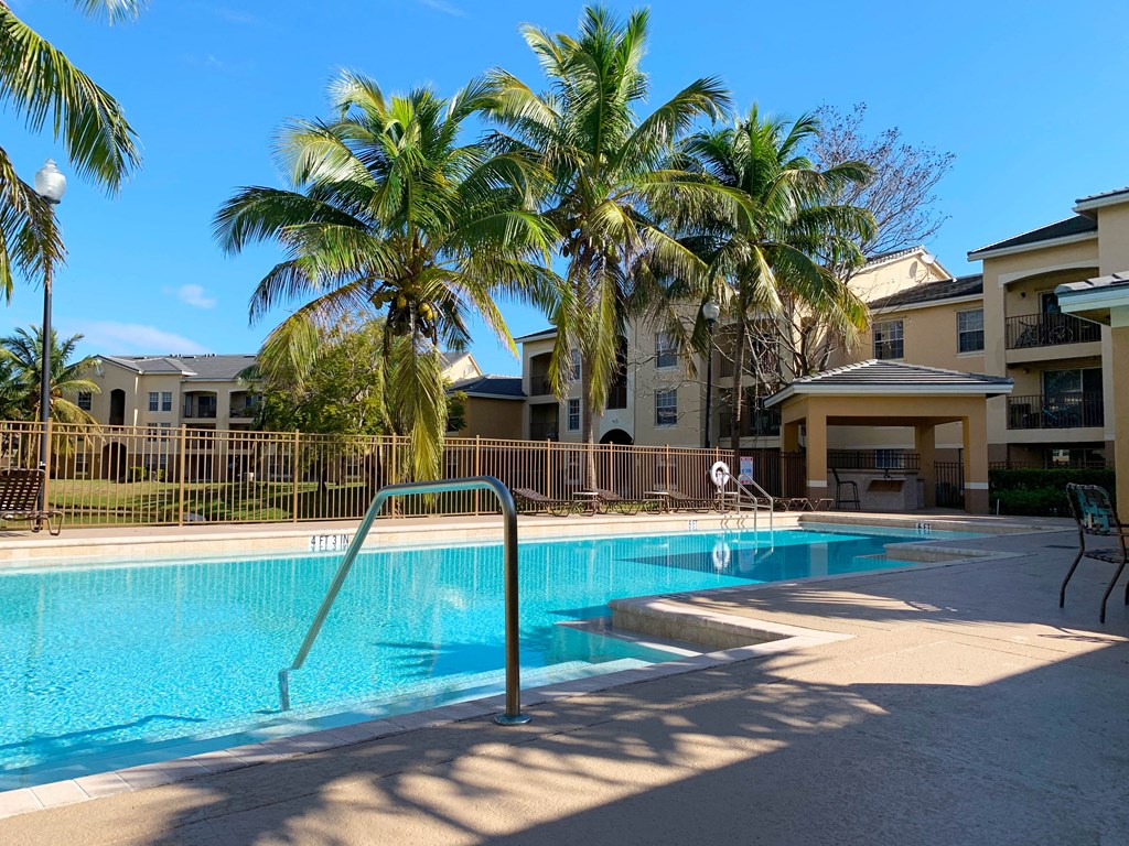 Portofino Apartments resort style pool and lounge chairs with palm trees