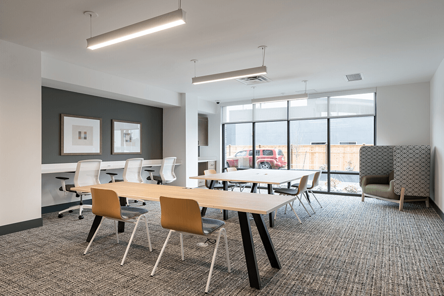a room with a table and chairs and a large window