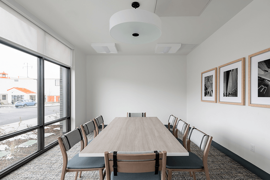 a conference room with a long wooden table and chairs