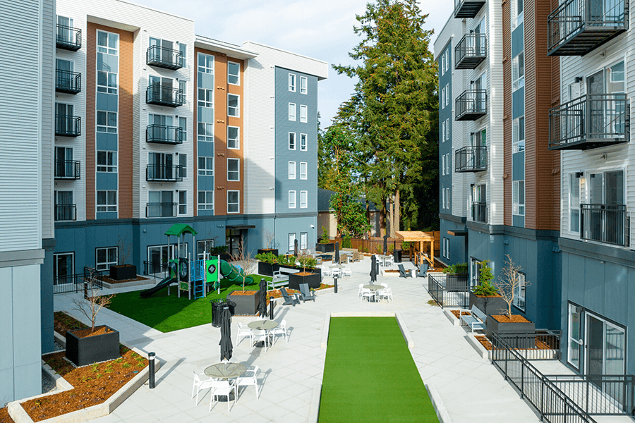 Apartments for Rent in Shoreline, WA - Quinn by Vintage - Courtyard with Seating Area, Playground, and View of Apartments Complex