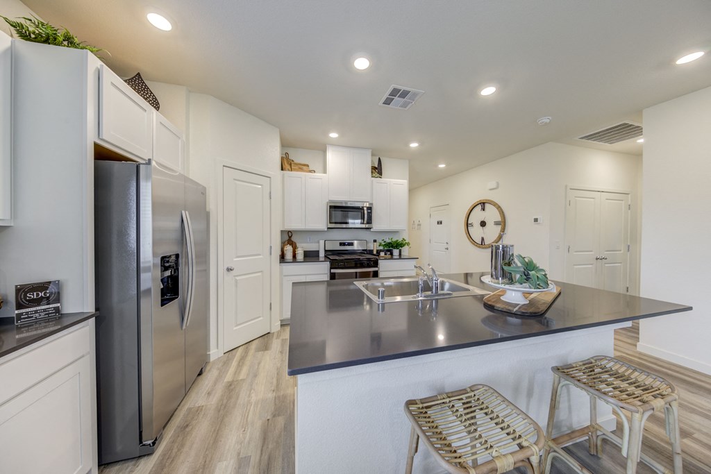 a modern kitchen with stainless steel appliances and white cabinetry