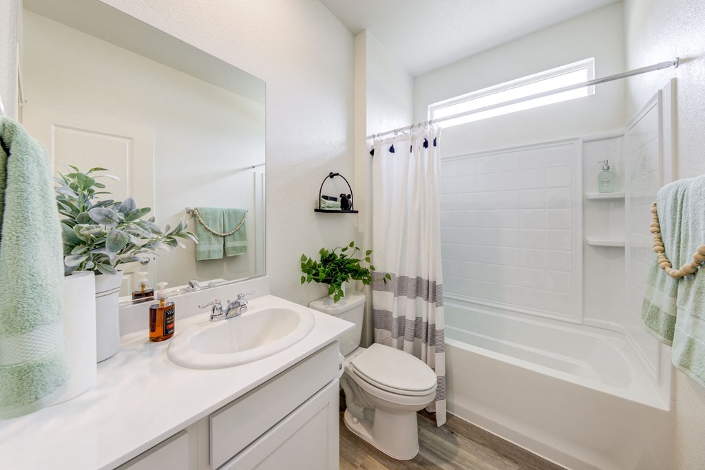 Homes For Rent In Fernley - The Pines at Ponderosa - Bathroom With Luxury Vinyl Plank Flooring, Modern Cabinetry, Sink With Plenty Of Counterspace, Vanity Mirror, Shower And Tub Combo, And Tile