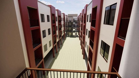 A long hallway with red and white buildings on either side at Vintage at Lockwood Apartments, Oxnard, California