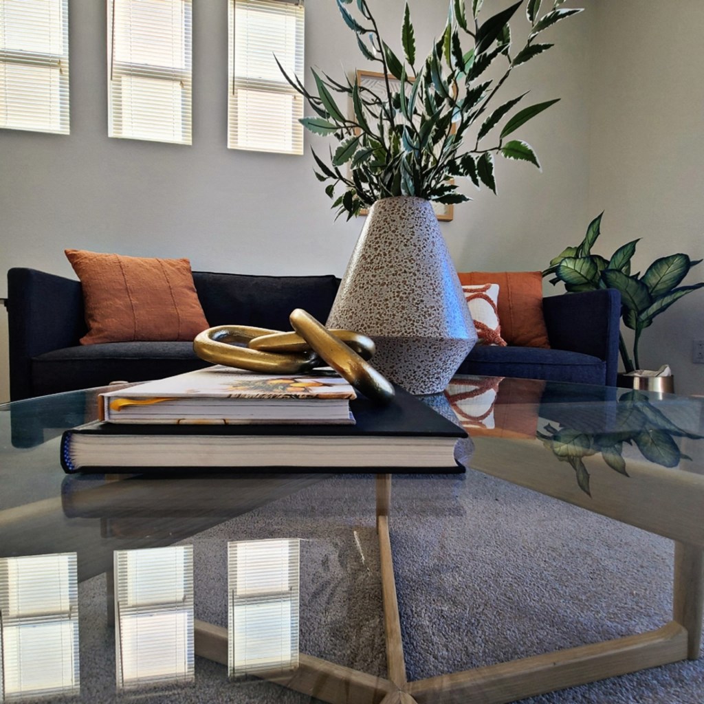 a living room with a coffee table with books and a vase