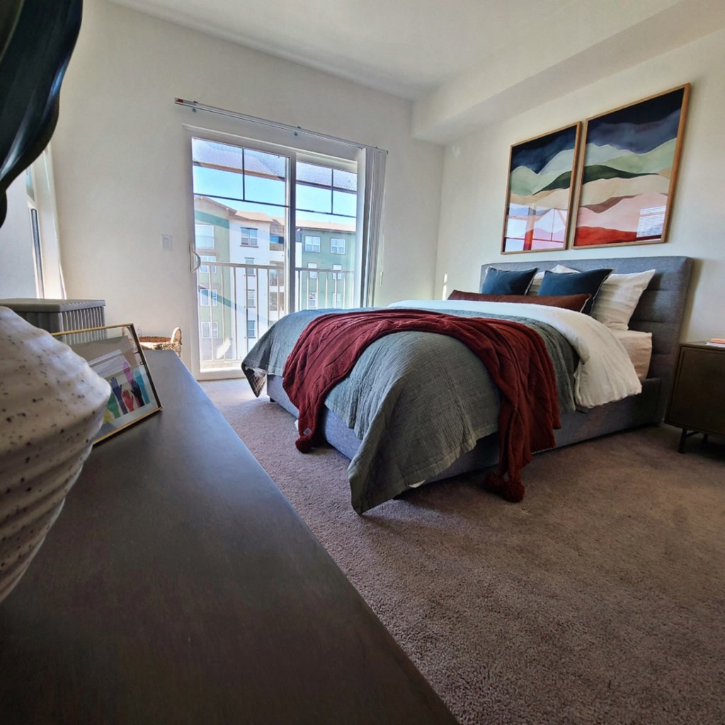 a bedroom with a bed and a large window