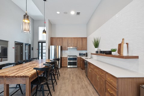 a large kitchen with a long wooden table and chairs