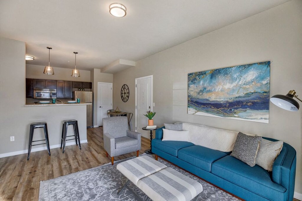 3 BR Apartments in Airway Heights WA - Salish Flats - Stylish Living Room With a Comfy Couch, a Chair, a Footrest, and a Large Rug