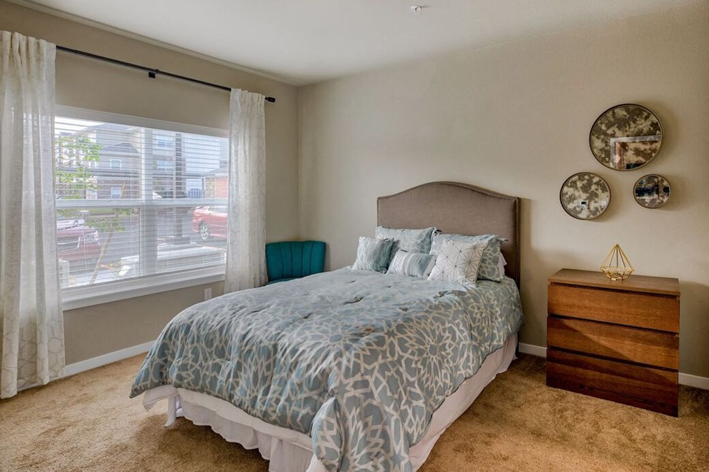 Apartments Near Sunset Park-Salish Flats-Bedroom with High Ceilings, Carpet Flooring, and a Large Window