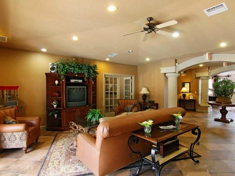 a living room filled with furniture and a ceiling fan