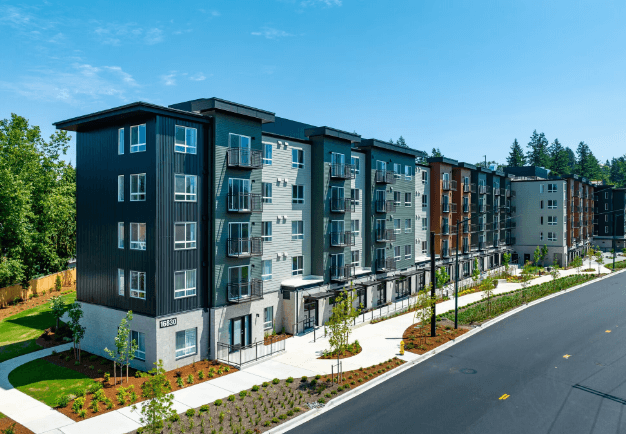 a rendering of a large apartment building with a street in front of it at STATION BY VINTAGE, COVINGTON, WA 98042