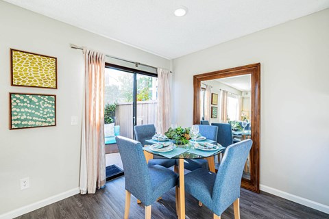 a dining room with a glass table and chairs at SERRANO HIGHLANDS APARTMENT HOMES, Lake Forest, 92630-7006