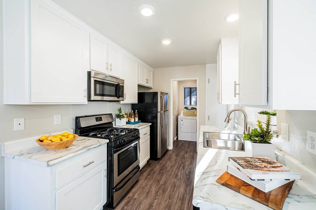 a kitchen with white cabinets and black appliances