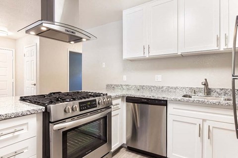 a kitchen with stainless steel appliances and white cabinets