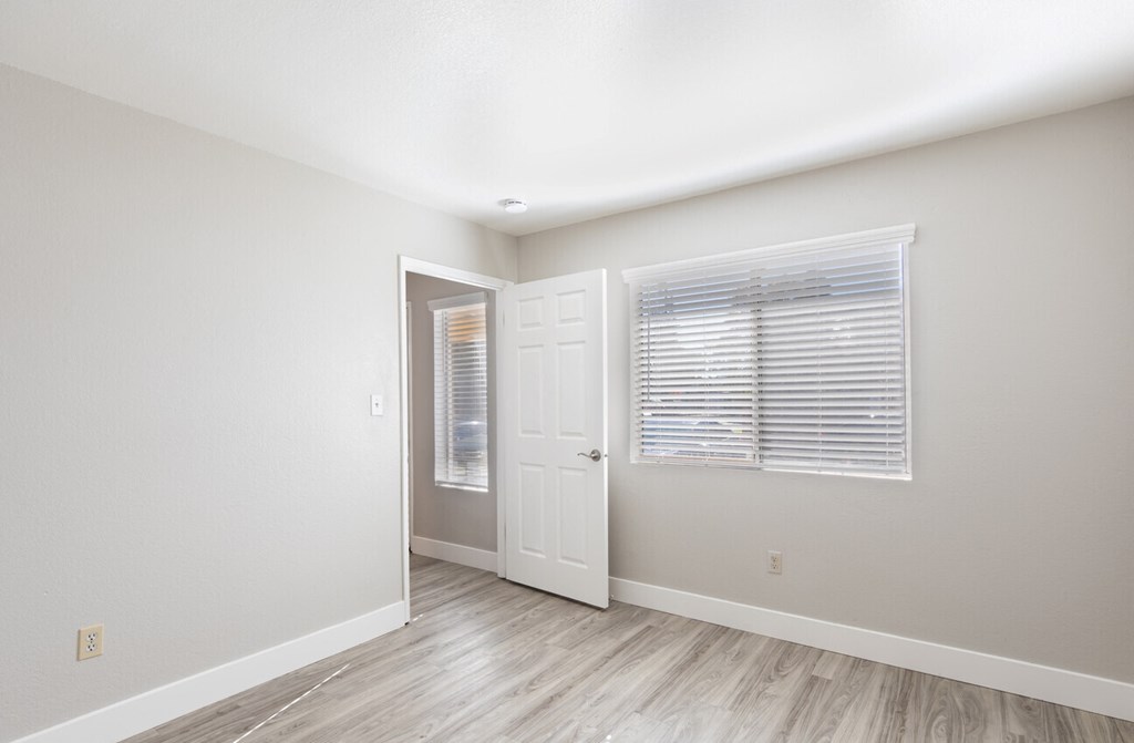 Large room with wood floors and window