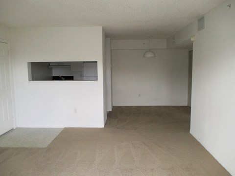 an empty living room with white walls and a microwave