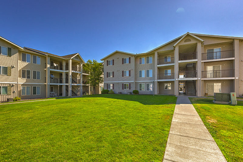 Apartment complex with a green lawn in front.