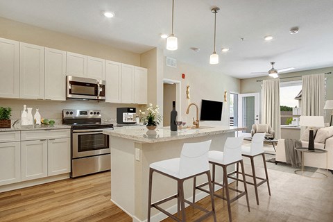 A modern kitchen with white cabinets and a center island.
