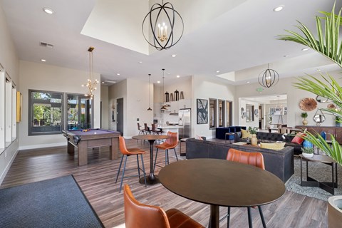 A modern living room with a pool table and a dining table.